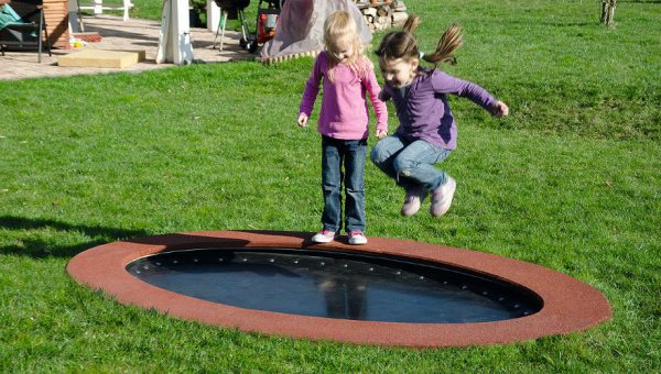 Ebenerdiges Trampolin auf einem Campingplatz mit spielenden Kindern